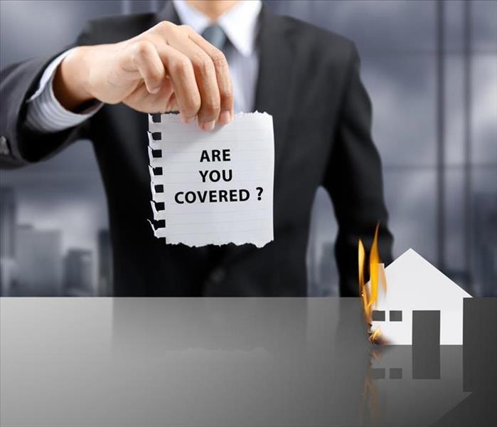 businessman present insurance concept with house on fire